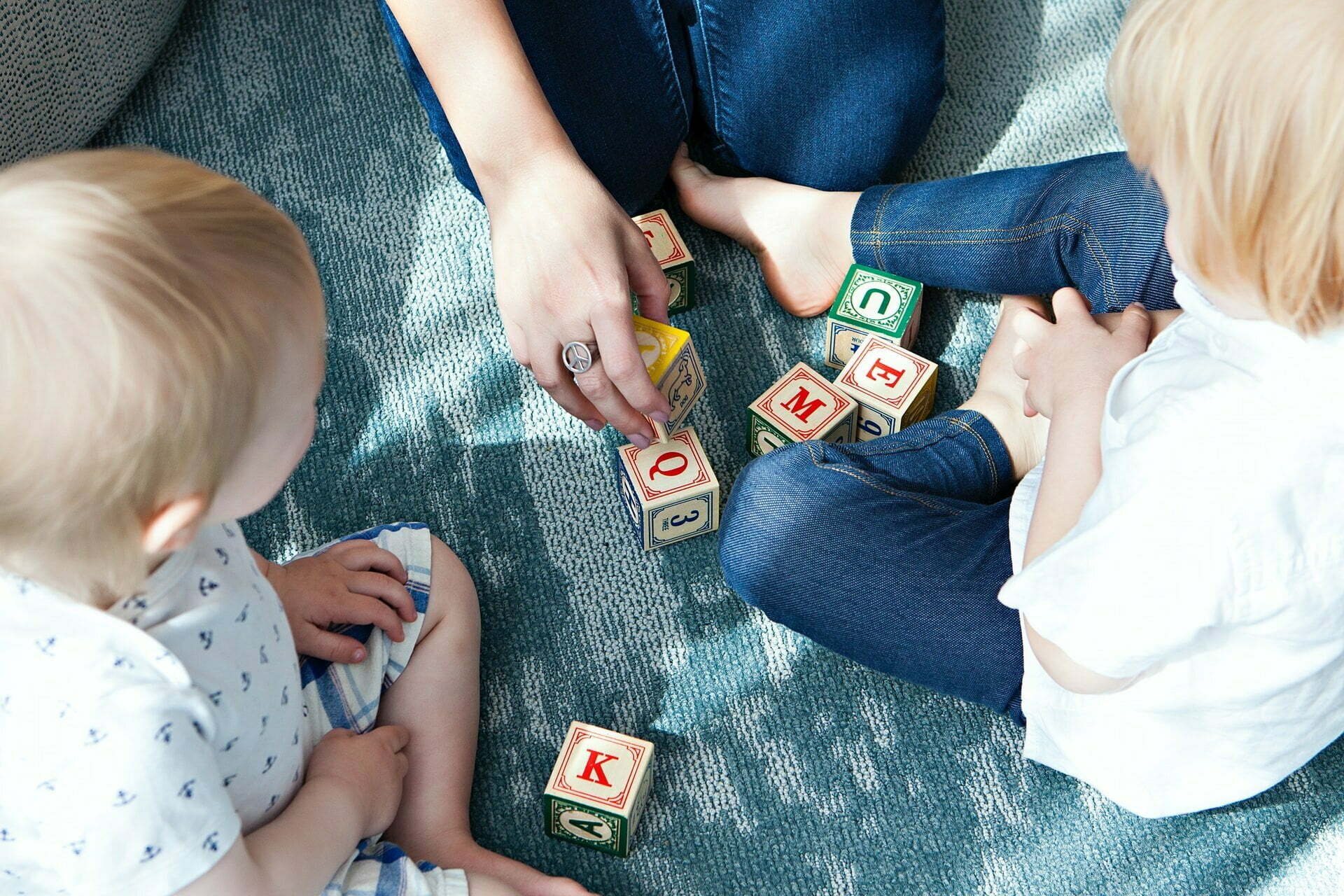 a group of people sitting on the floor playing with toys